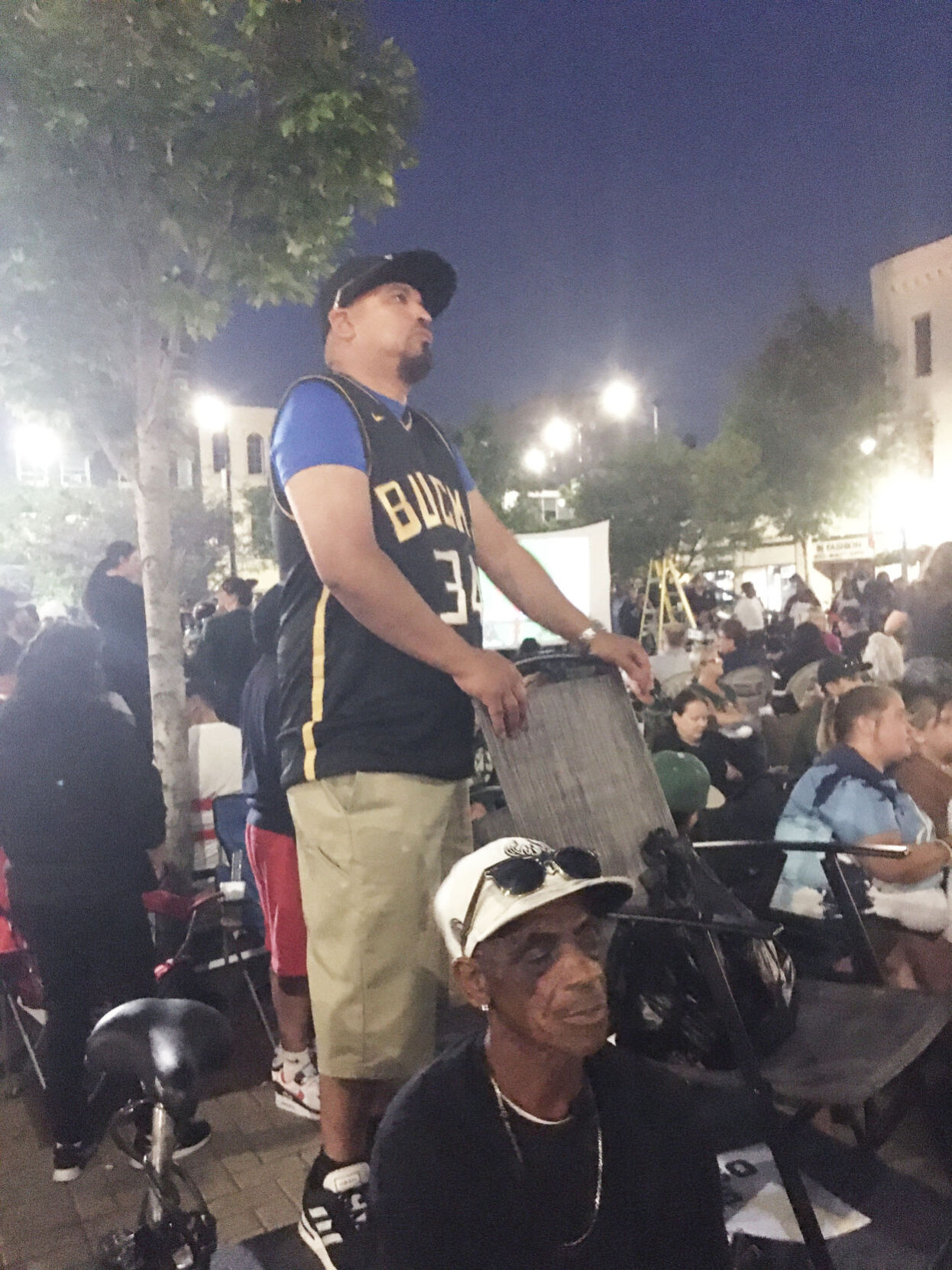 Santiago Anaya stands on elevated stoop during Bucks championship watch party